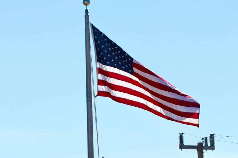 United States flag waving on a pole with a clear blue sky background in Florida.
