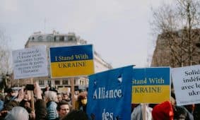 A peaceful demonstration featuring protestors with signs supporting Ukraine against invasion.