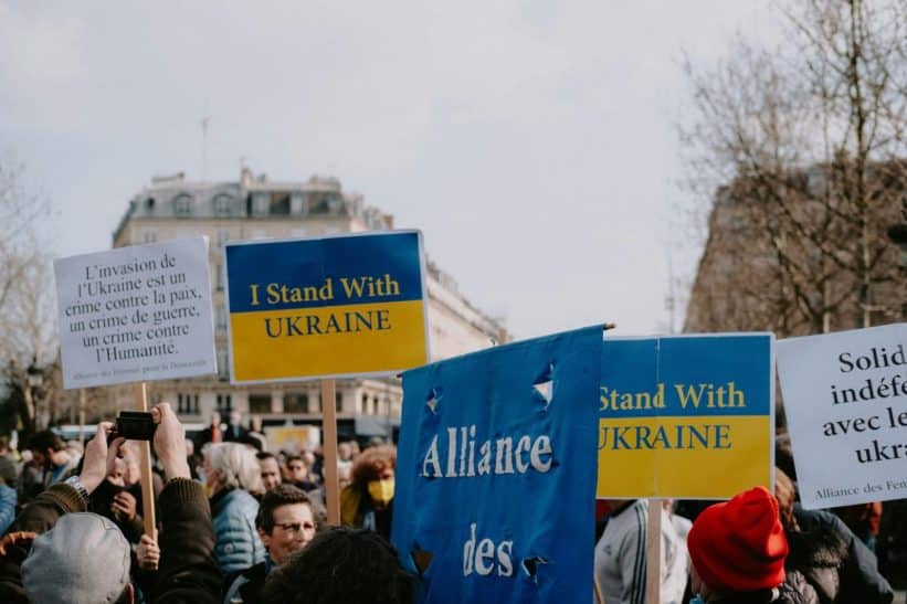 A peaceful demonstration featuring protestors with signs supporting Ukraine against invasion.