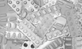 Monochrome close-up of assorted blister packs with pills, highlighting pharmaceutical packaging.