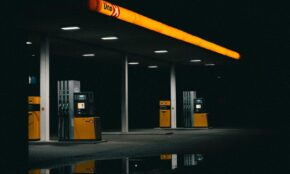 A moody nighttime photo of an empty gas station with orange lights.