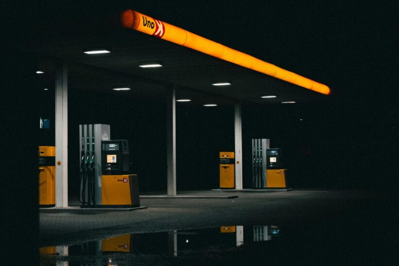 A moody nighttime photo of an empty gas station with orange lights.