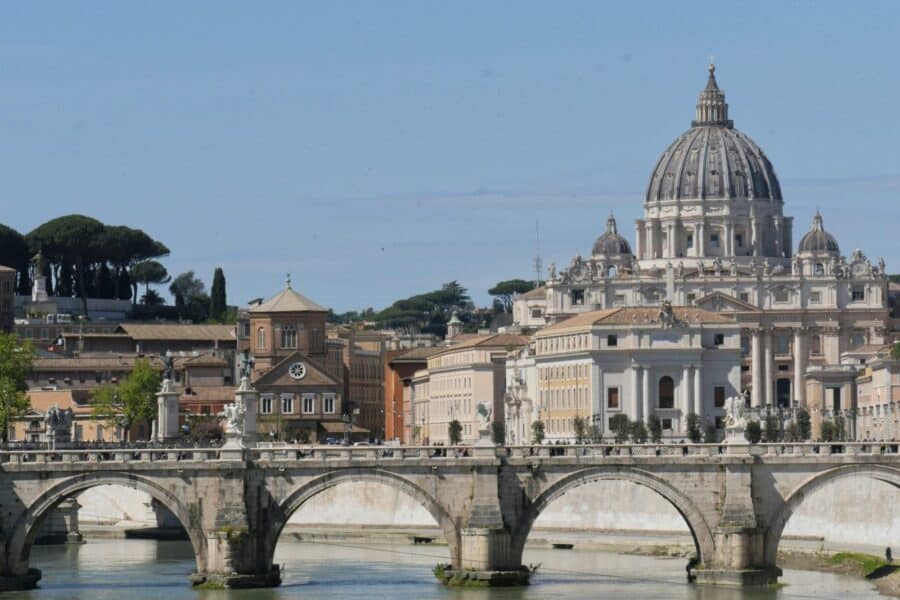 View of St. Peter's Basilica behind Angels Bridge over the Tiber River, Rome.