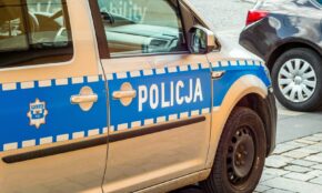 Detailed shot of a Polish police car parked on a cobblestone street.
