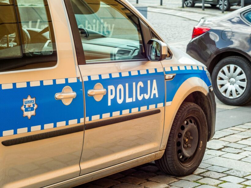 Detailed shot of a Polish police car parked on a cobblestone street.
