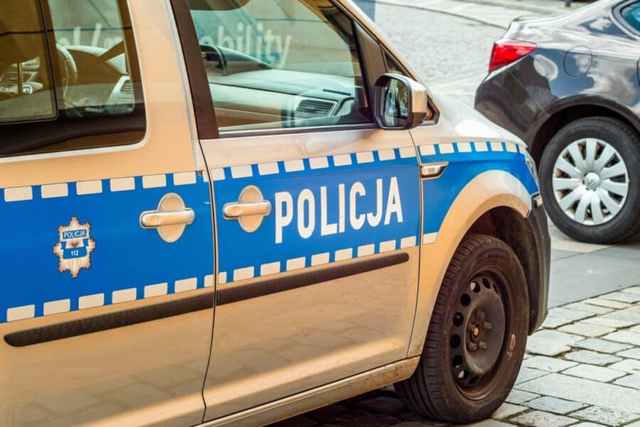 Detailed shot of a Polish police car parked on a cobblestone street.