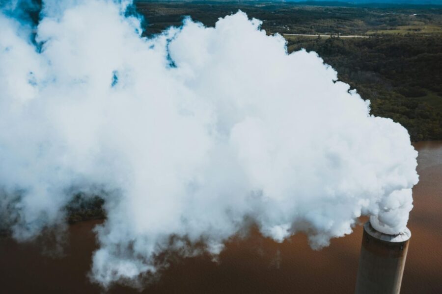 From above of thick fume stream coming out of masonry smokestack at power plant