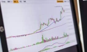 Close-up of a trading screen showing an increasing stock market chart.