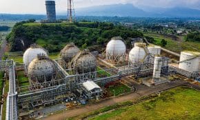 Aerial shot of a power plant with storage tanks in lush Banten, Indonesia offers an impressive scale.