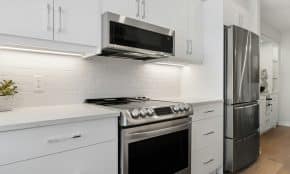 a kitchen with white cabinets and stainless steel appliances