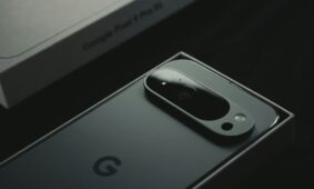 A close up of a cell phone near a laptop