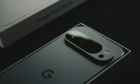 A close up of a cell phone near a laptop