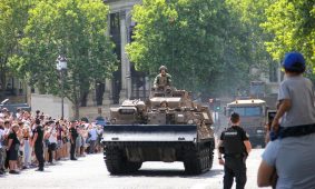 a large group of people watching a military vehicle