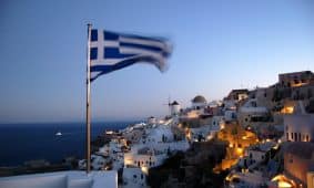 Flag of Greece waving at pole at Santorino, Greece
