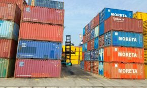 a forklift is moving a large stack of shipping containers