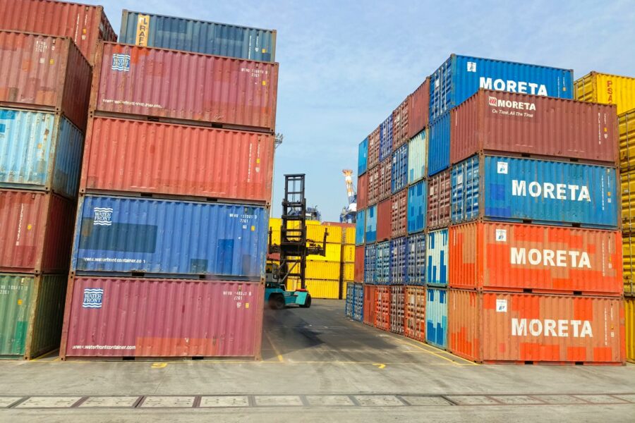 a forklift is moving a large stack of shipping containers