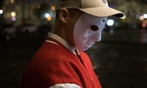 a man wearing a white mask and a red jacket