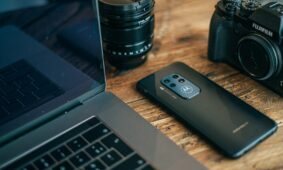 black smartphone beside MacBook Pro