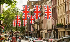 a british flag hanging over a city street