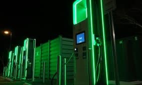 a row of green gas pumps at night