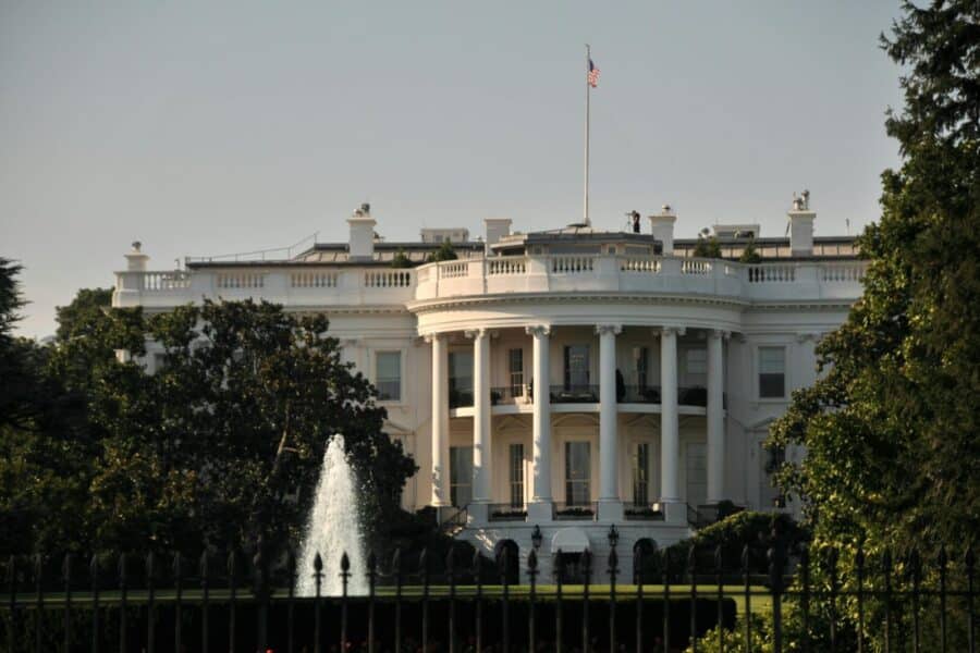 The stately White House with its iconic architecture surrounded by lush greenery, featuring a majestic fountain.
