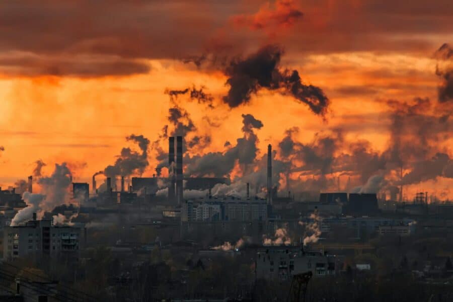 Dramatic sunset over Cherepovets industrial skyline with factory smoke and pollution.