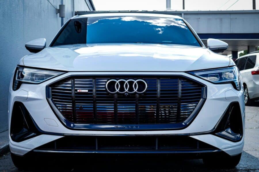 Sleek white Audi E-Tron SUV captured outdoors with a modern design.