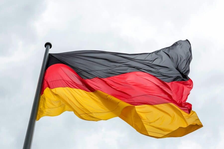 Waving German flag against a cloudy sky, featuring vibrant colors.