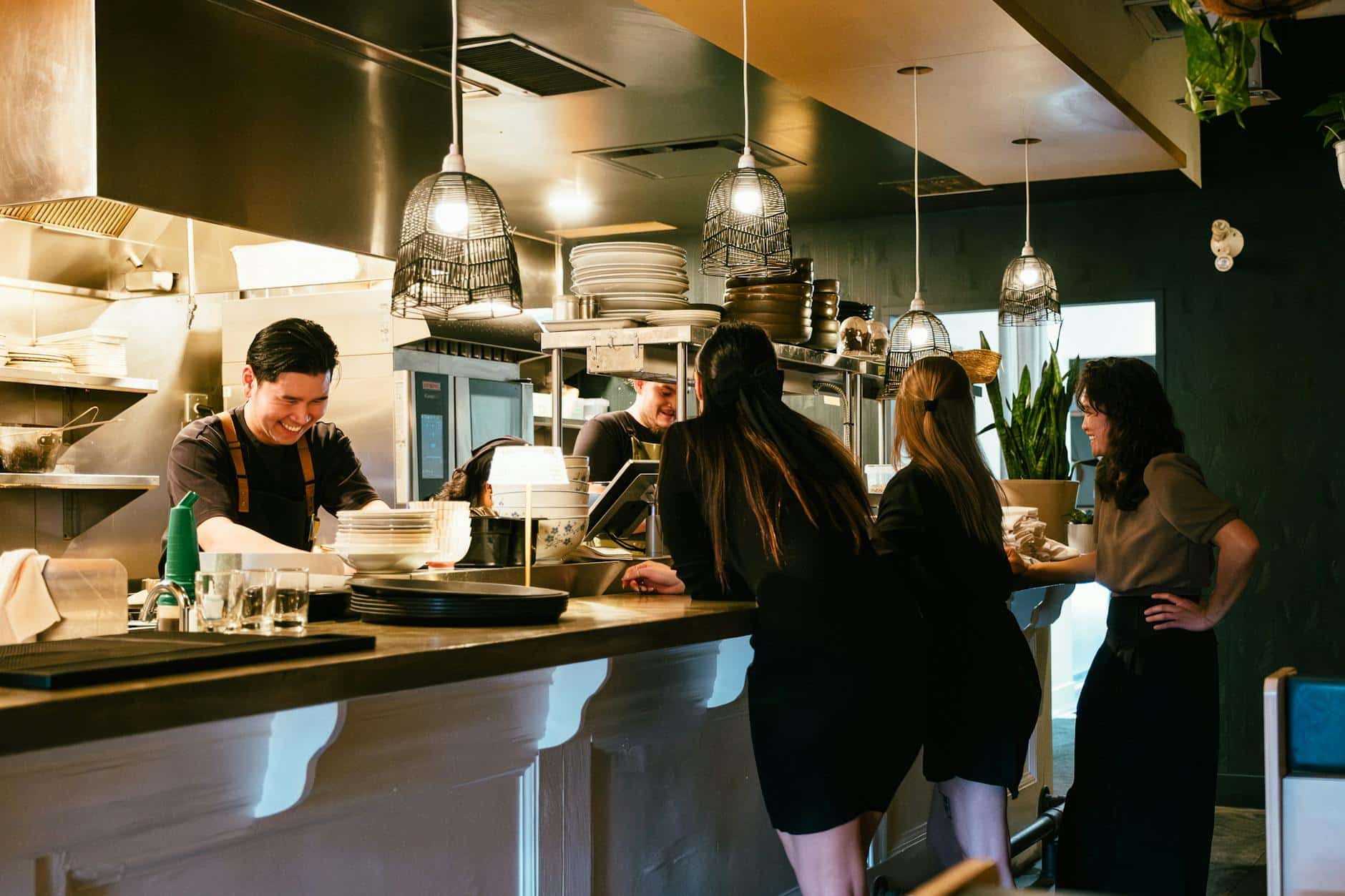 Restaurant kitchen staff cooking restaurant customers dining inside